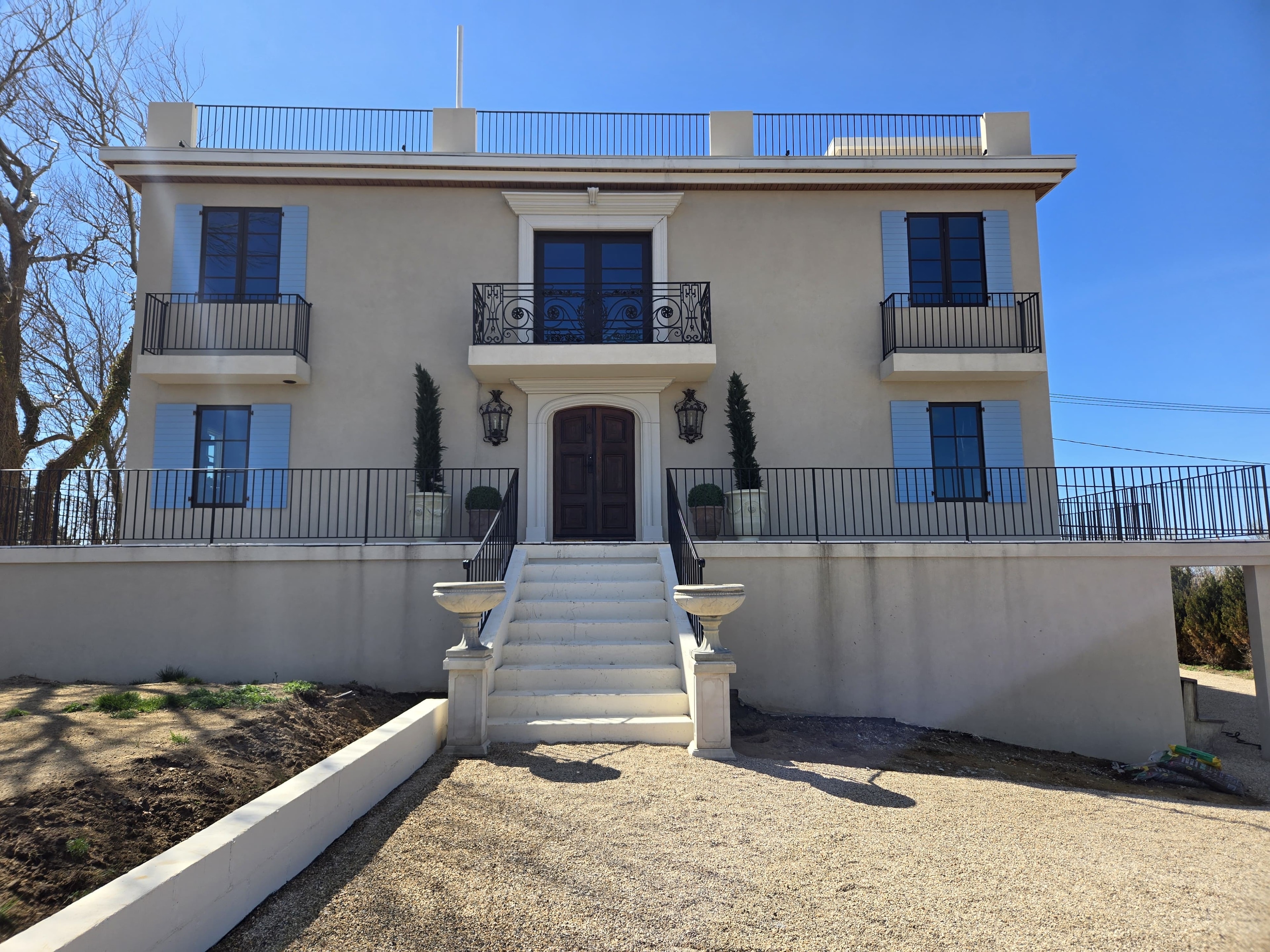 Full home build — Oak Beach: front facade with grand staircase, arched entry, ornamental lanterns and blue shutters
