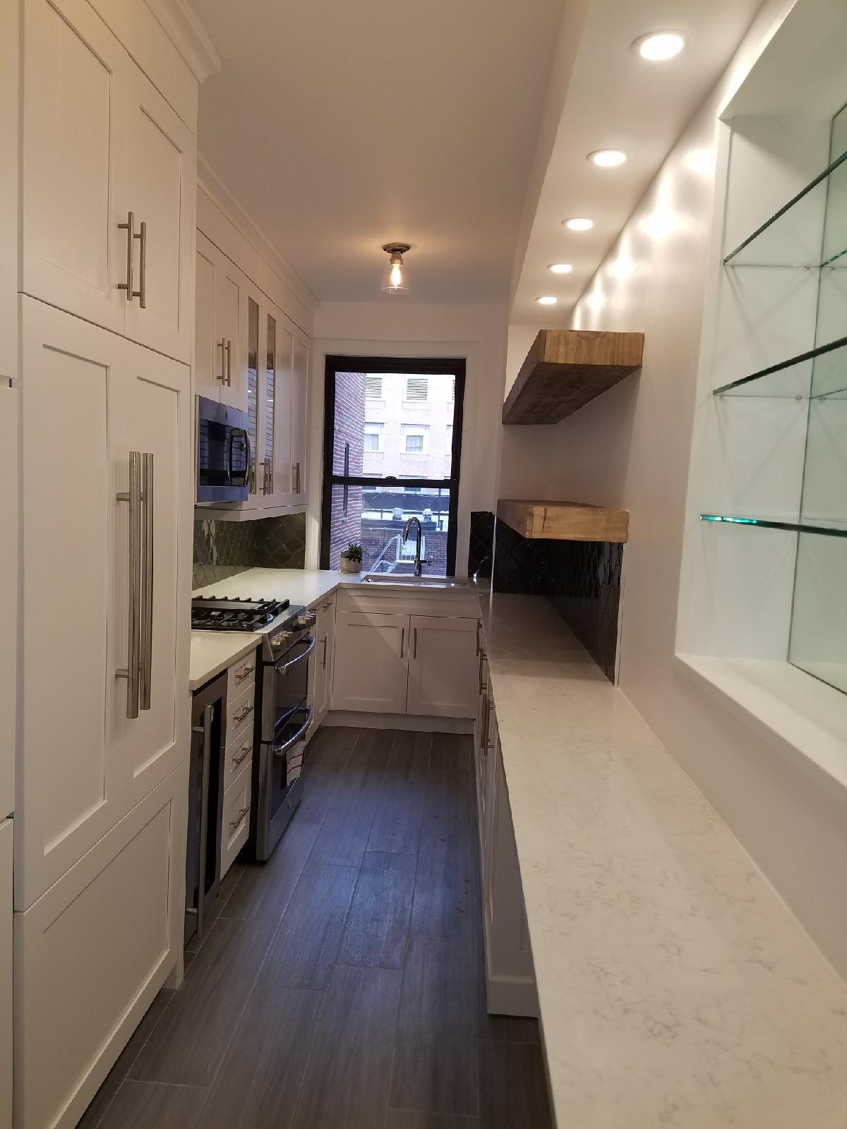 Galley kitchen renovation with white shaker cabinets and open shelving