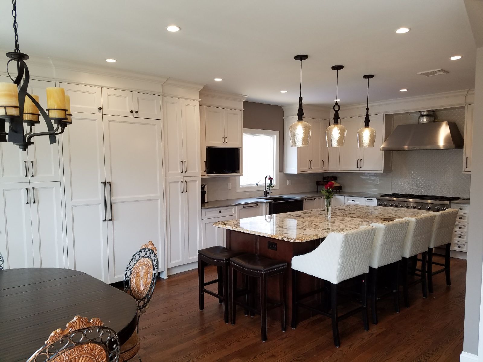 Kitchen renovation with white cabinetry and granite island